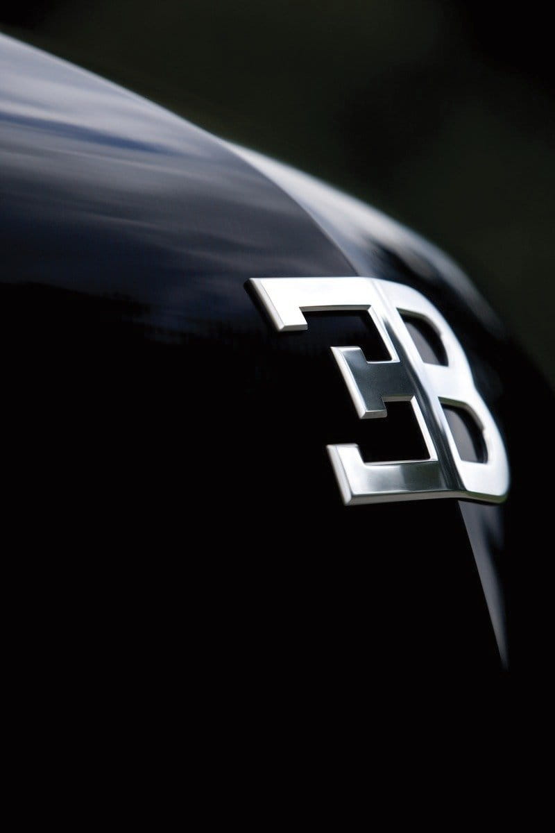 Primer plano del emblemático logo de Bugatti sobre la superficie curva del Galibier.