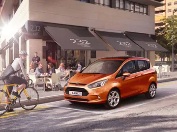 Ford B-MAX en tonalidad naranja circulando por el entorno urbano