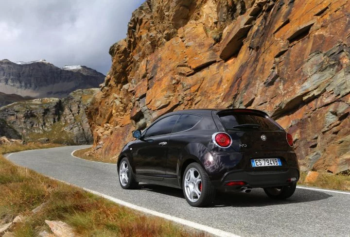 Vista trasera y lateral del Alfa Romeo MiTo en carretera de montaña.