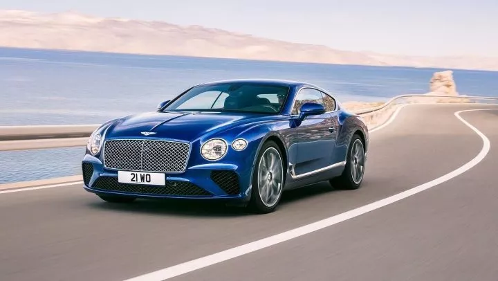Bentley Continental GT mostrando su elegancia al conducir cerca del mar.
