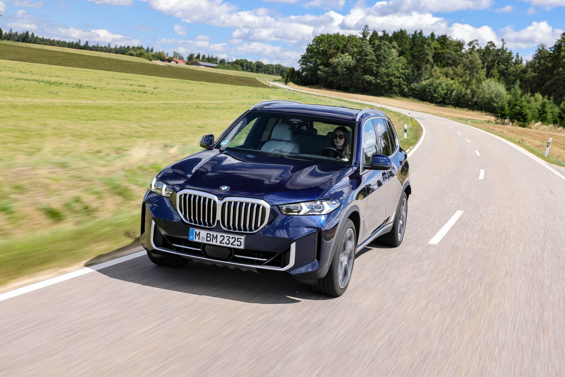 BMW X5 en dinámica sobre asfalto, vista delantera y lateral.