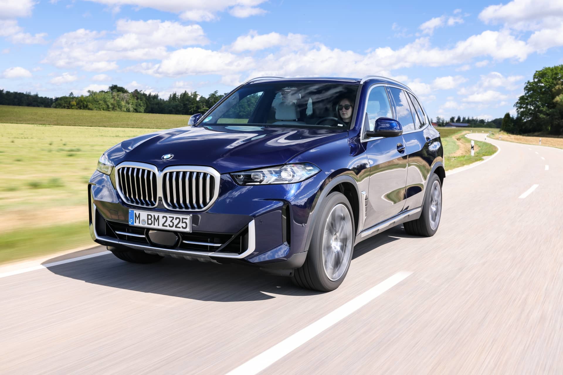 Vista dinámica del BMW X5 en movimiento, destacando su diseño lateral.