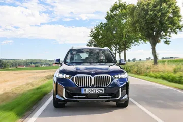 Vista delantera y lateral del BMW X5 en movimiento.