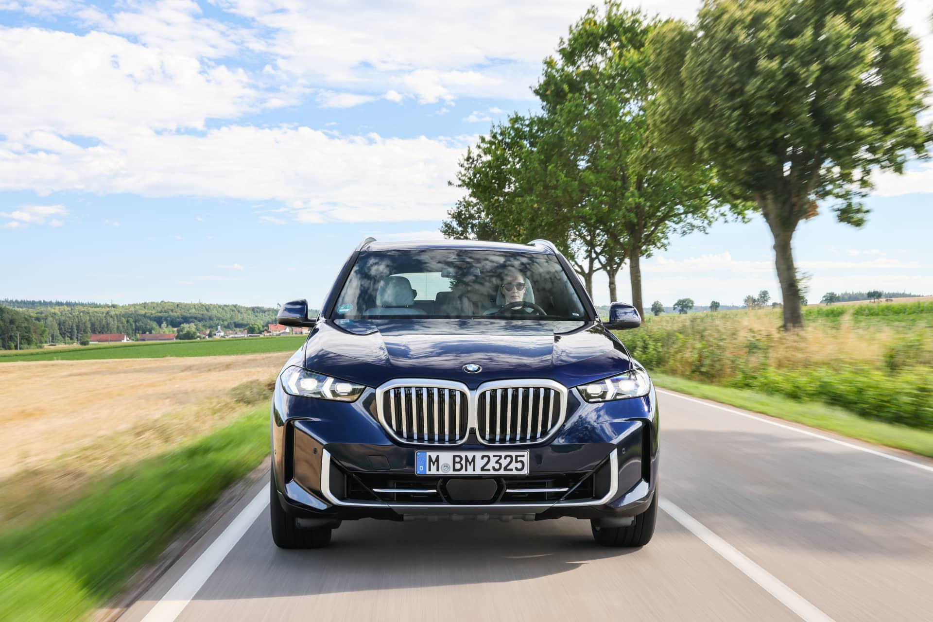Vista delantera y lateral del BMW X5 en movimiento.