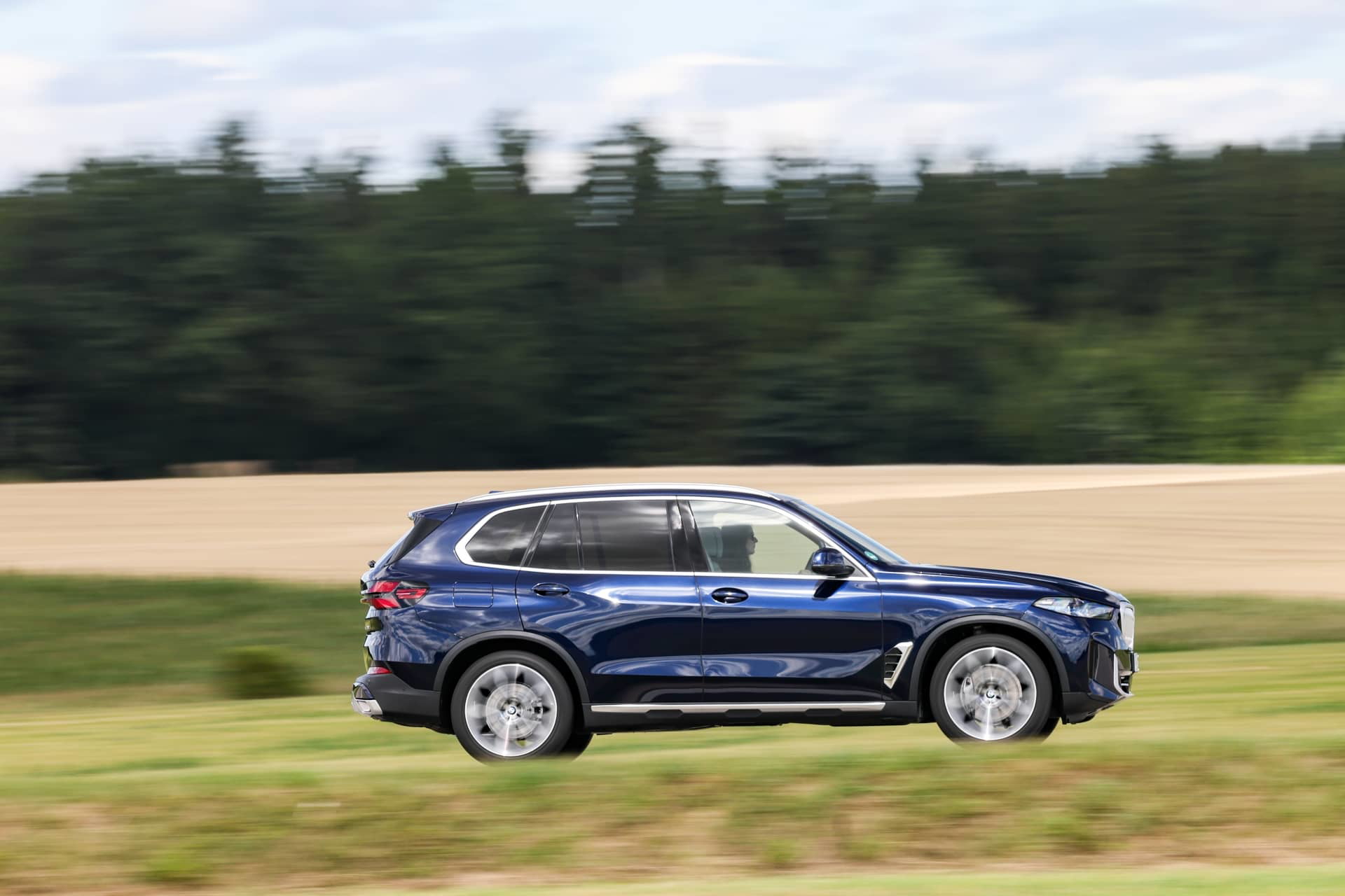 Vista lateral del BMW X5 en movimiento, mostrando su diseño aerodinámico.