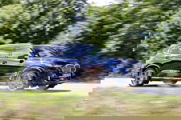 BMW X5 en movimiento mostrando su perfil lateral y diseño dinámico.