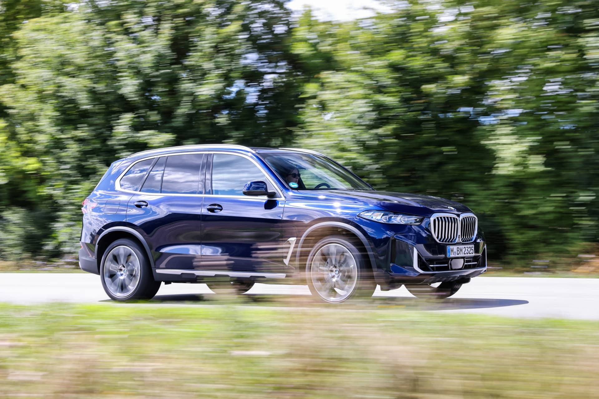 BMW X5 en movimiento mostrando su perfil lateral y diseño dinámico.