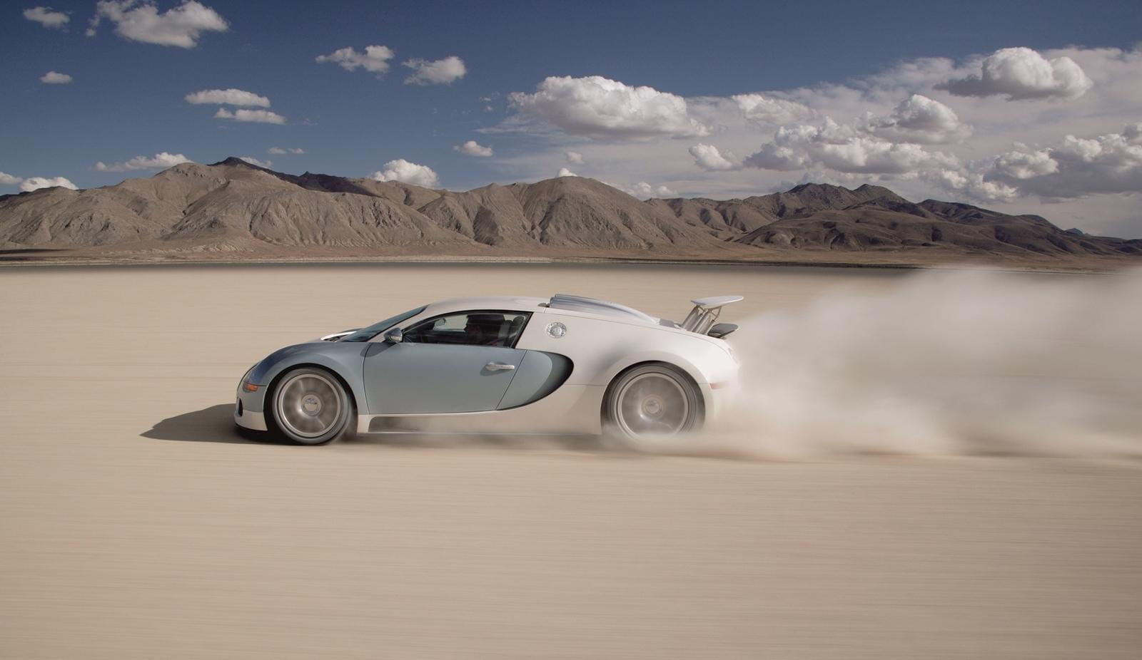 Bugatti Veyron desplegando potencia y velocidad en terreno arenoso.