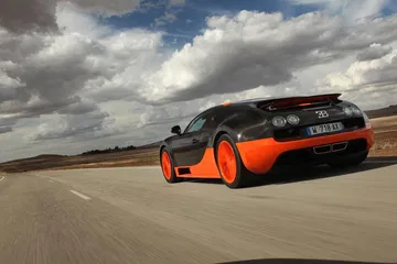 Vista dinámica de un Bugatti Veyron en movimiento, enfatizando su perfil lateral.