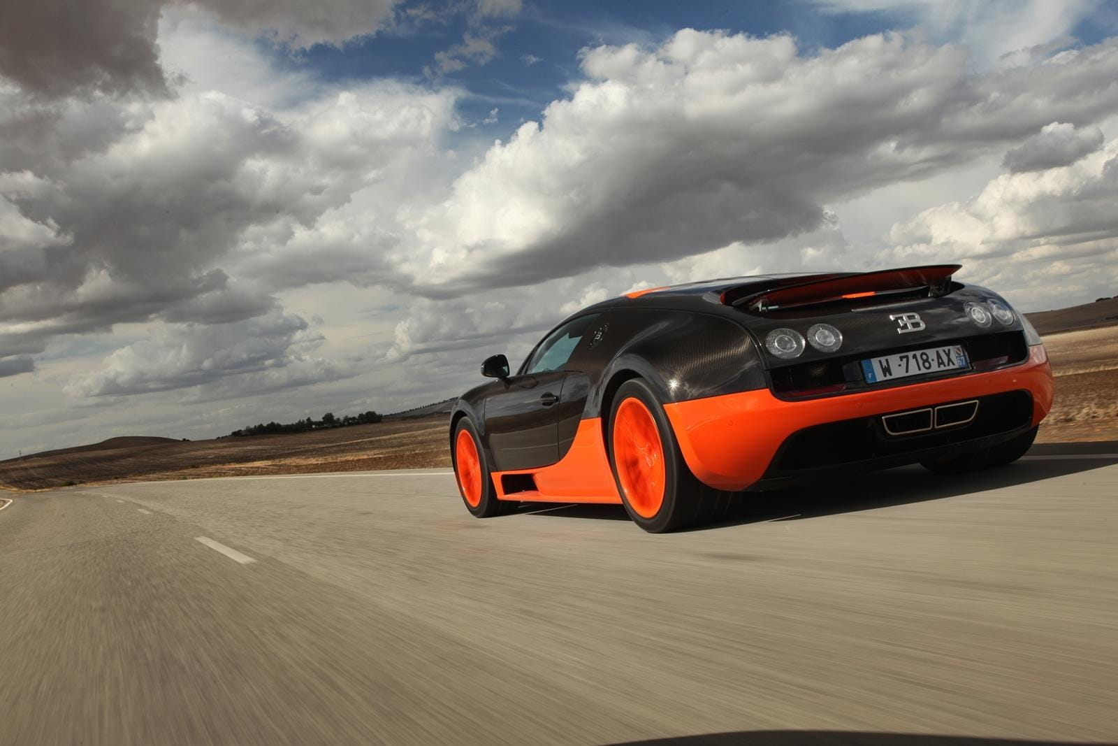 Vista dinámica de un Bugatti Veyron en movimiento, enfatizando su perfil lateral.