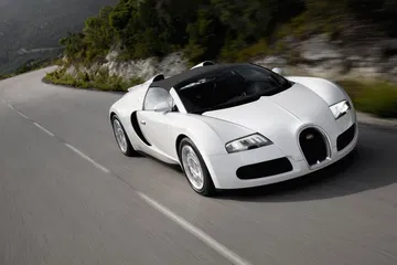Vista dinámica del Bugatti Veyron en carretera, destacando su diseño frontal y lateral.