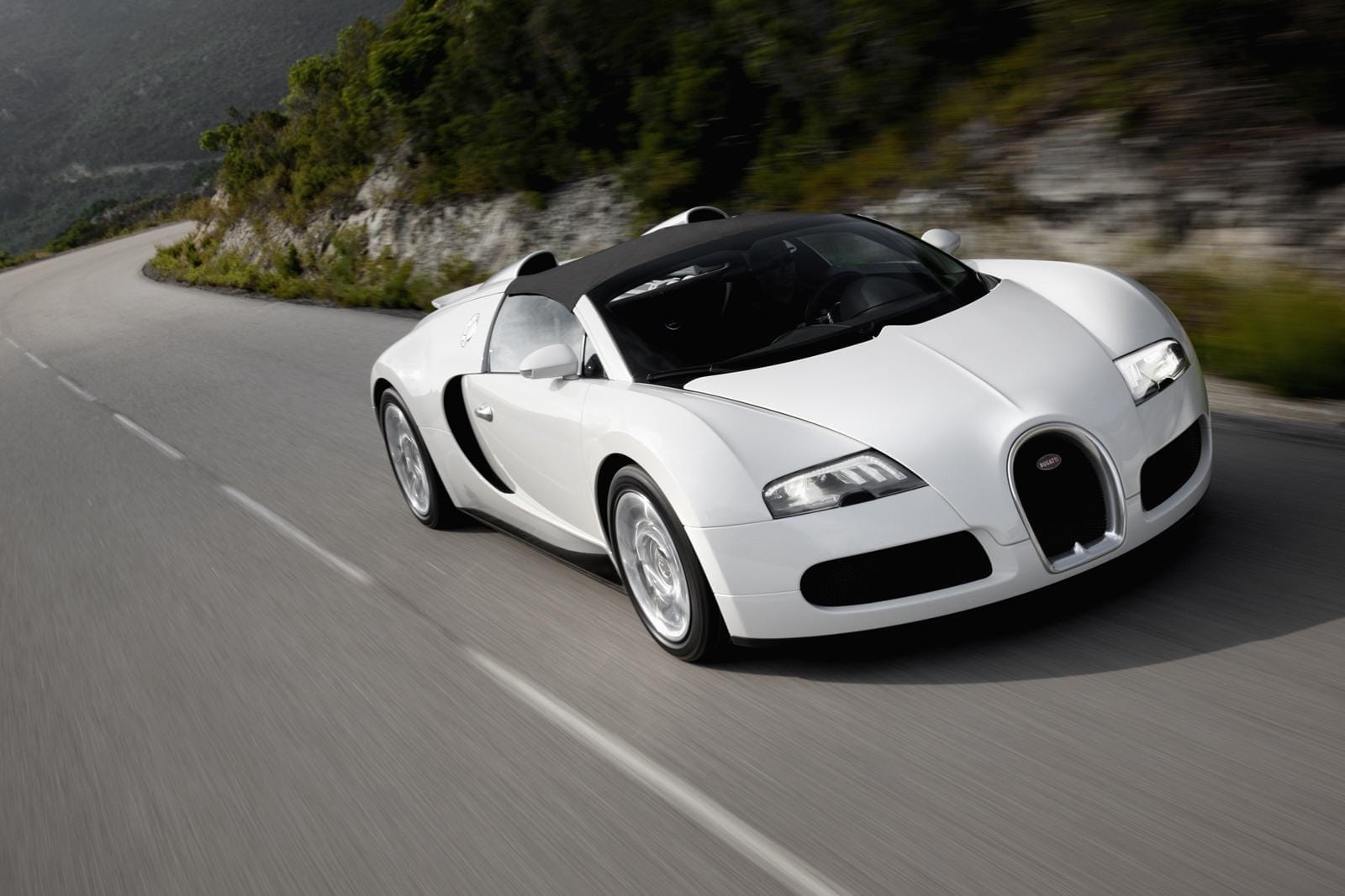 Vista dinámica del Bugatti Veyron en carretera, destacando su diseño frontal y lateral.