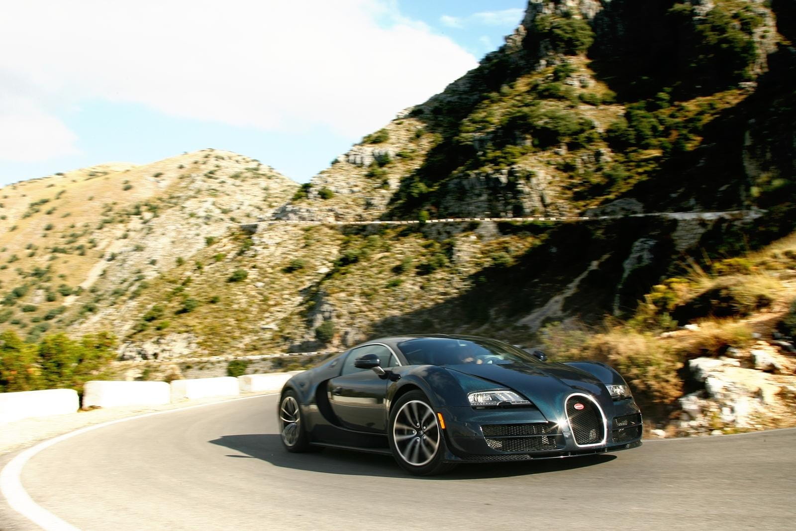 Vista lateral del Bugatti Veyron en una carretera de montaña.