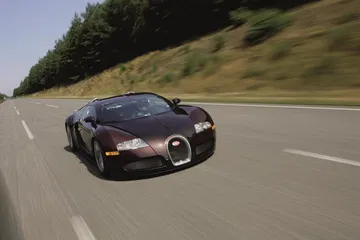 Bugatti Veyron capturado en pleno movimiento, vista delantera y lateral.