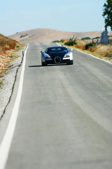 Vista frontal del Bugatti Veyron en movimiento, enfatizando su diseño agresivo.