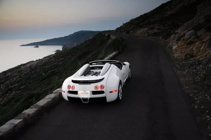 Vista posterior y lateral del imponente Bugatti Veyron rodando en carretera al atardecer.