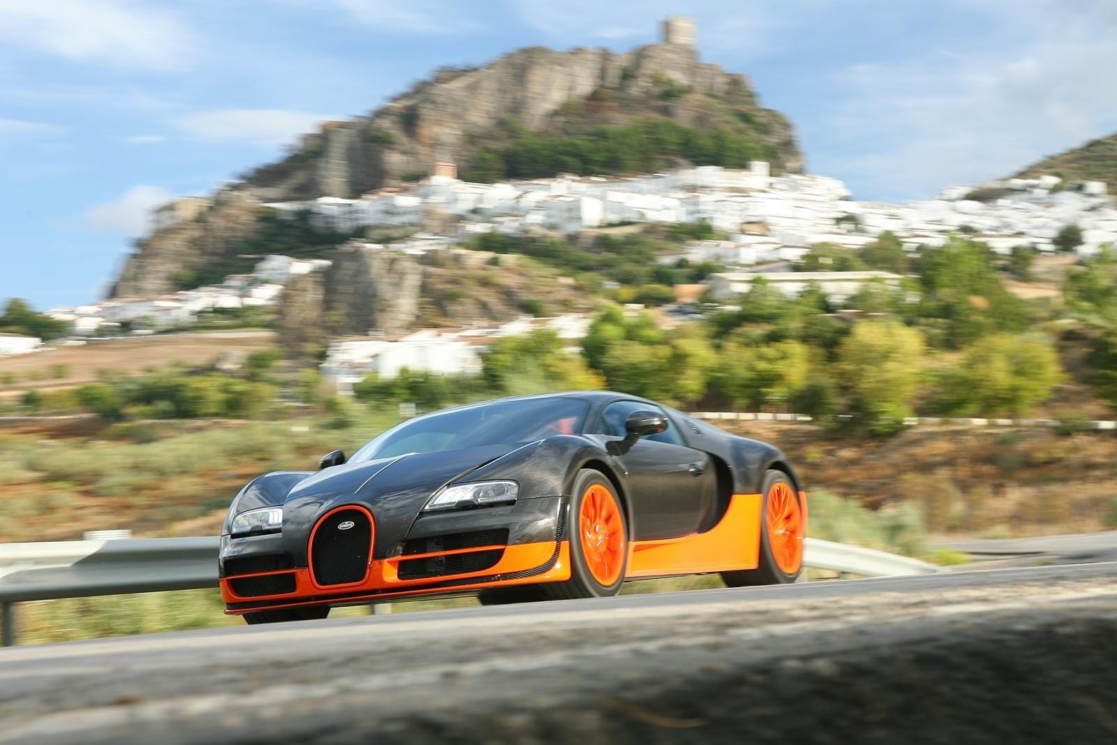 Vista lateral del Bugatti Veyron en movimiento, destacando su aerodinámica y diseño.