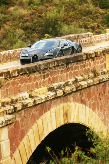 Vista lateral de un Bugatti Veyron aparcado, mostrando su línea aerodinámica.