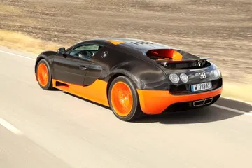 Vista lateral de un Bugatti Veyron en movimiento, destacando su diseño aerodinámico.