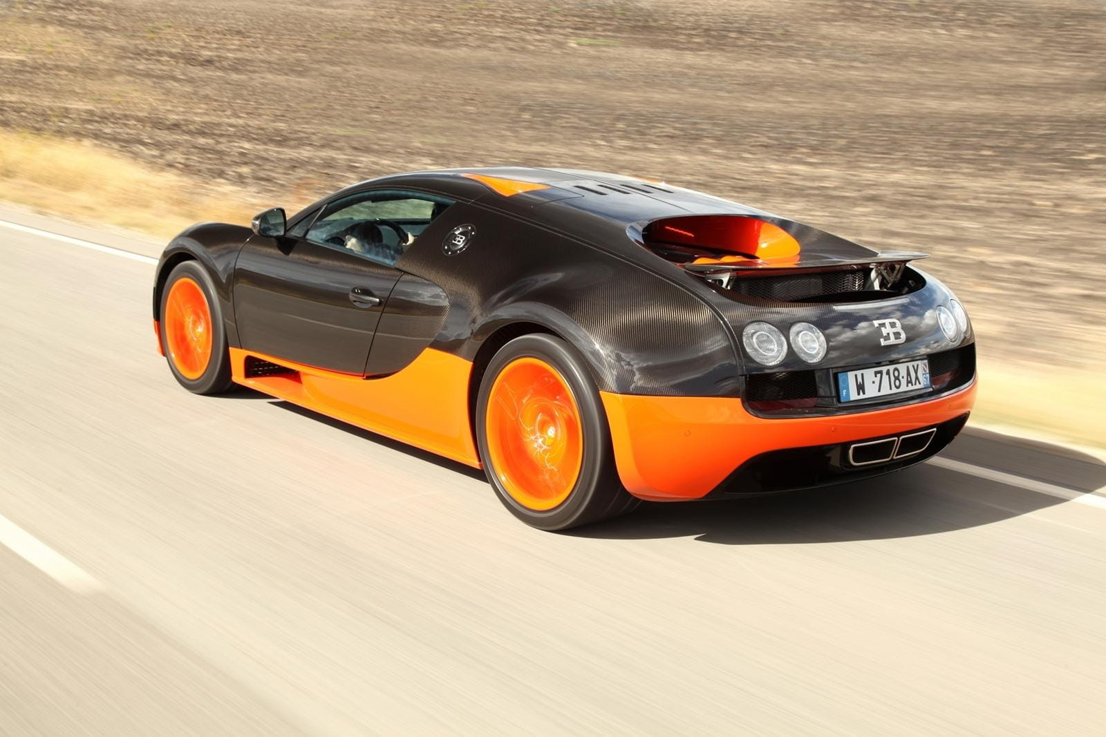 Vista lateral de un Bugatti Veyron en movimiento, destacando su diseño aerodinámico.