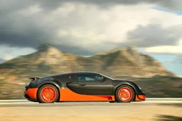Vista dinámica lateral del Bugatti Veyron en carretera abierta.