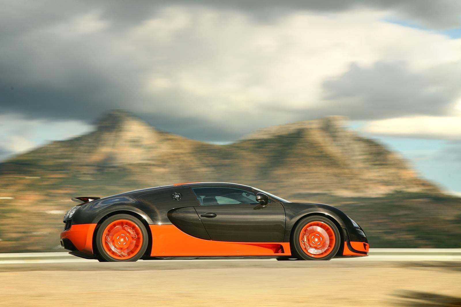 Vista dinámica lateral del Bugatti Veyron en carretera abierta.