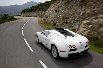 Vista dinámica lateral del Bugatti Veyron desplazándose en carretera