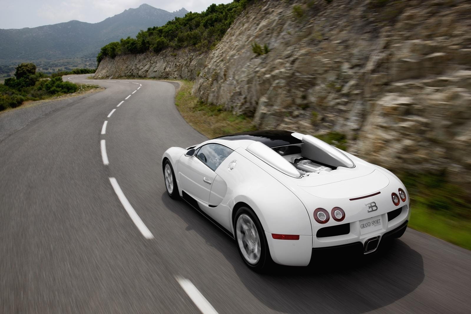 Vista dinámica lateral del Bugatti Veyron desplazándose en carretera