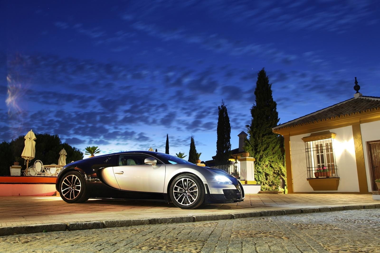 Vista lateral del Bugatti Veyron bajo iluminación nocturna, ejemplificando su diseño aerodinámico.