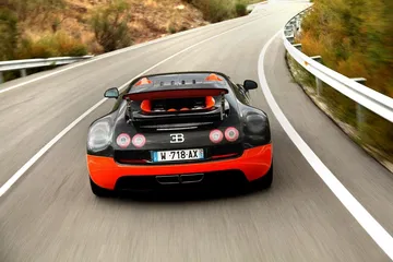 Bugatti Veyron capturado en acción, destacando su trasera y alerón desplegado.