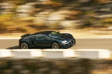 Vista dinámica lateral de un Bugatti Veyron en movimiento.