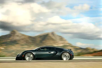 Vista lateral del Bugatti Veyron rodando con fondo de montañas.