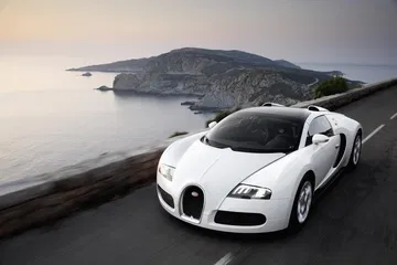 Vista delantera y lateral del Bugatti Veyron con paisaje al atardecer.