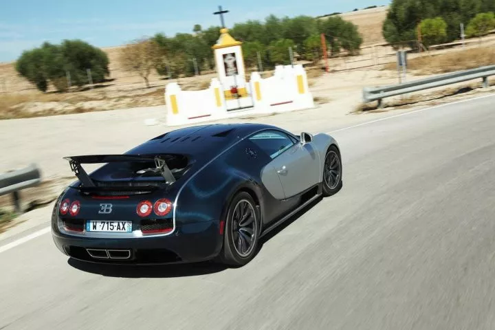 Vista dinámica del Bugatti Veyron en movimiento mostrando su perfil trasero.