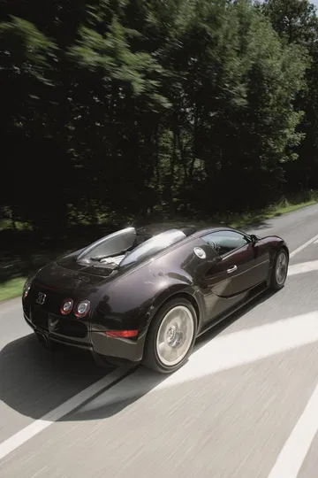 Vista lateral de un Bugatti Veyron en movimiento, subrayando su icónico diseño.