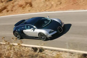Vista lateral del Bugatti Veyron en plena aceleración, capturando su silueta aerodinámica.