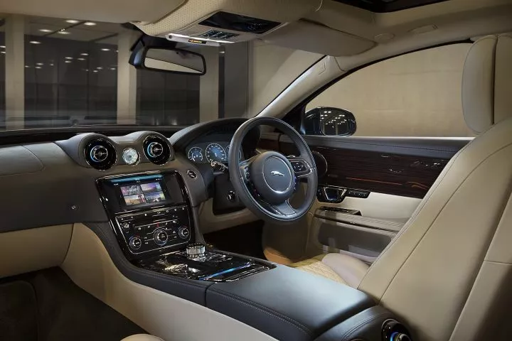 Vista lateral del puesto de conducción del Jaguar XJ, destacando su elegancia y ergonomía.