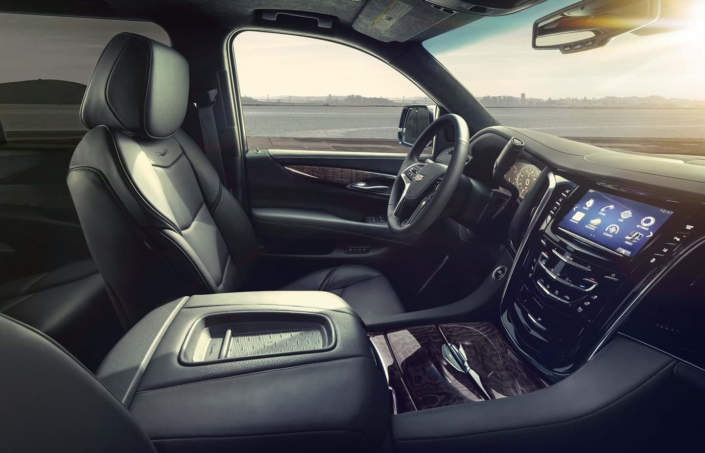 Vista en ángulo del lujoso habitáculo del Cadillac Escalade, destacando su tecnología.