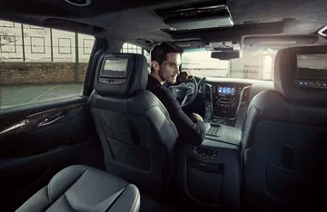 Vista del habitáculo lujoso con asientos de piel y pantallas traseras.