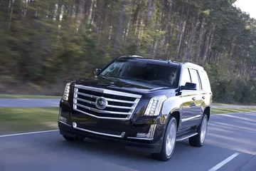 Cadillac Escalade en movimiento, vista delantera y lateral, que demuestra su imponente presencia.