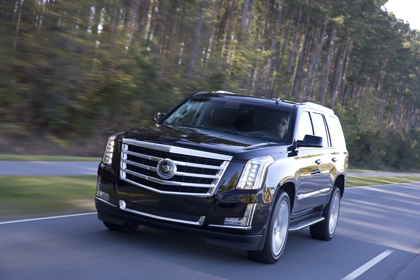 Cadillac Escalade en movimiento, vista delantera y lateral, que demuestra su imponente presencia.