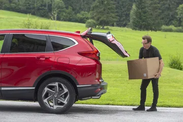 Hombre utilizando el maletero del Honda CR-V, apreciación de capacidad y diseño trasero.