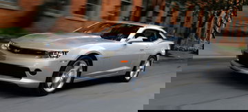 Vista lateral Chevrolet Camaro en movimiento, destacando su diseño aerodinámico.