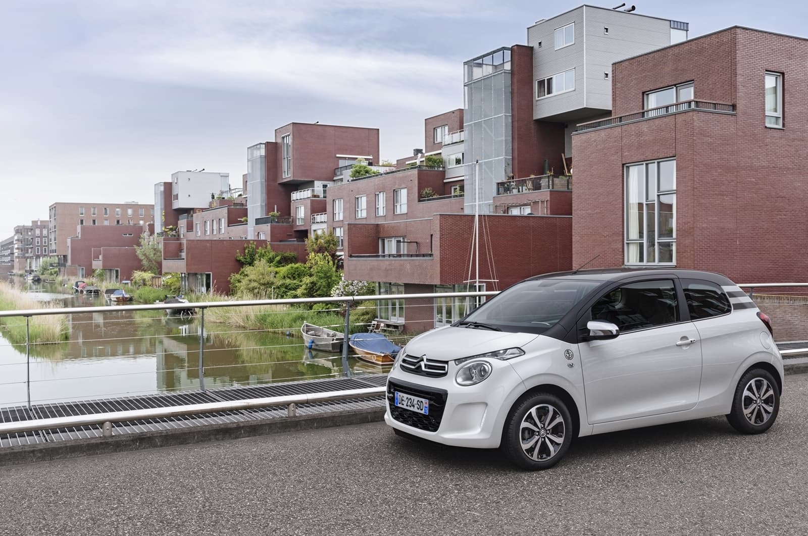 Vista lateral del Citroën C1 en un entorno urbano, reflejando su agilidad y tamaño compacto.