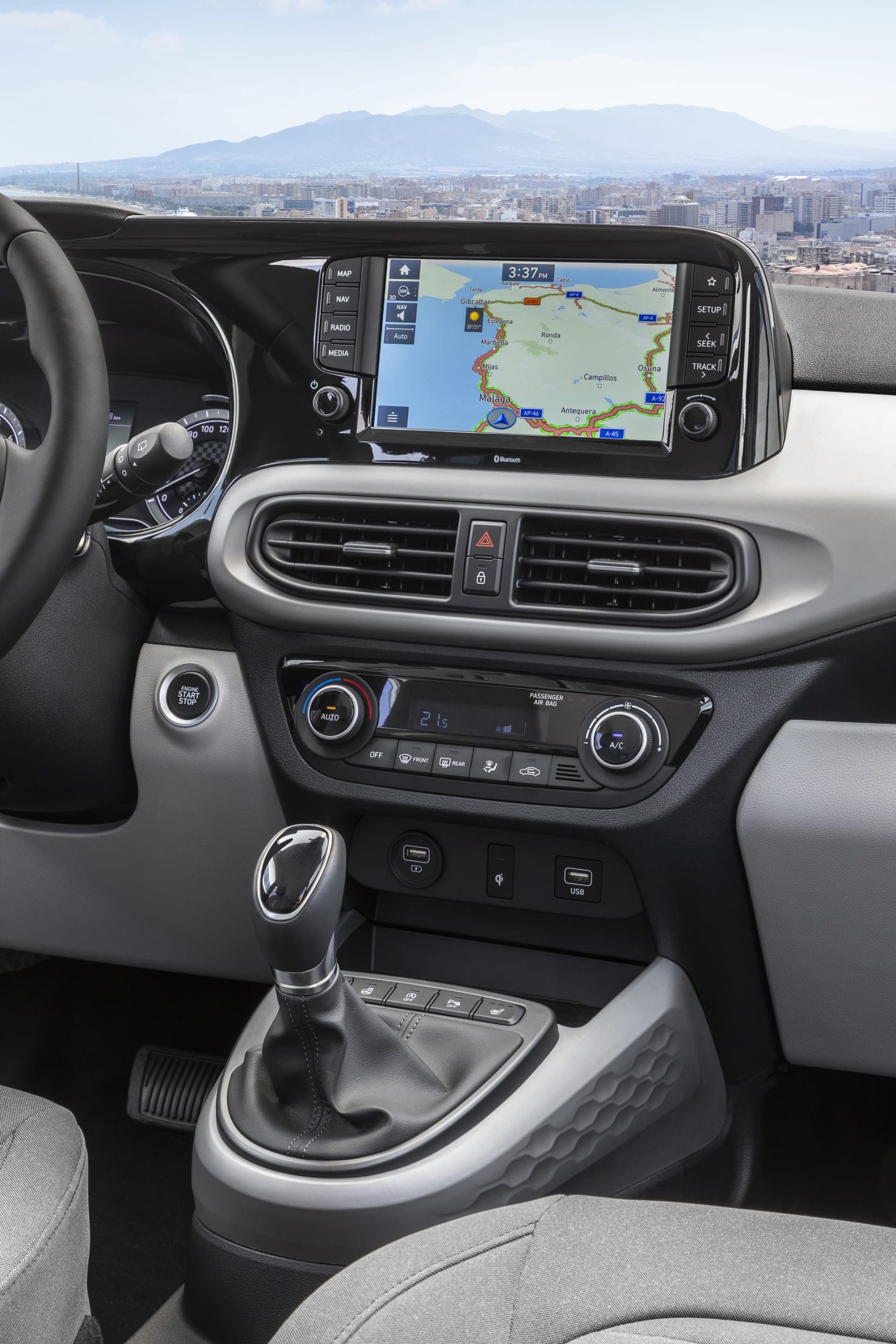Vista de la consola central del Hyundai i10 con sistema de infoentretenimiento y controles de climatización.