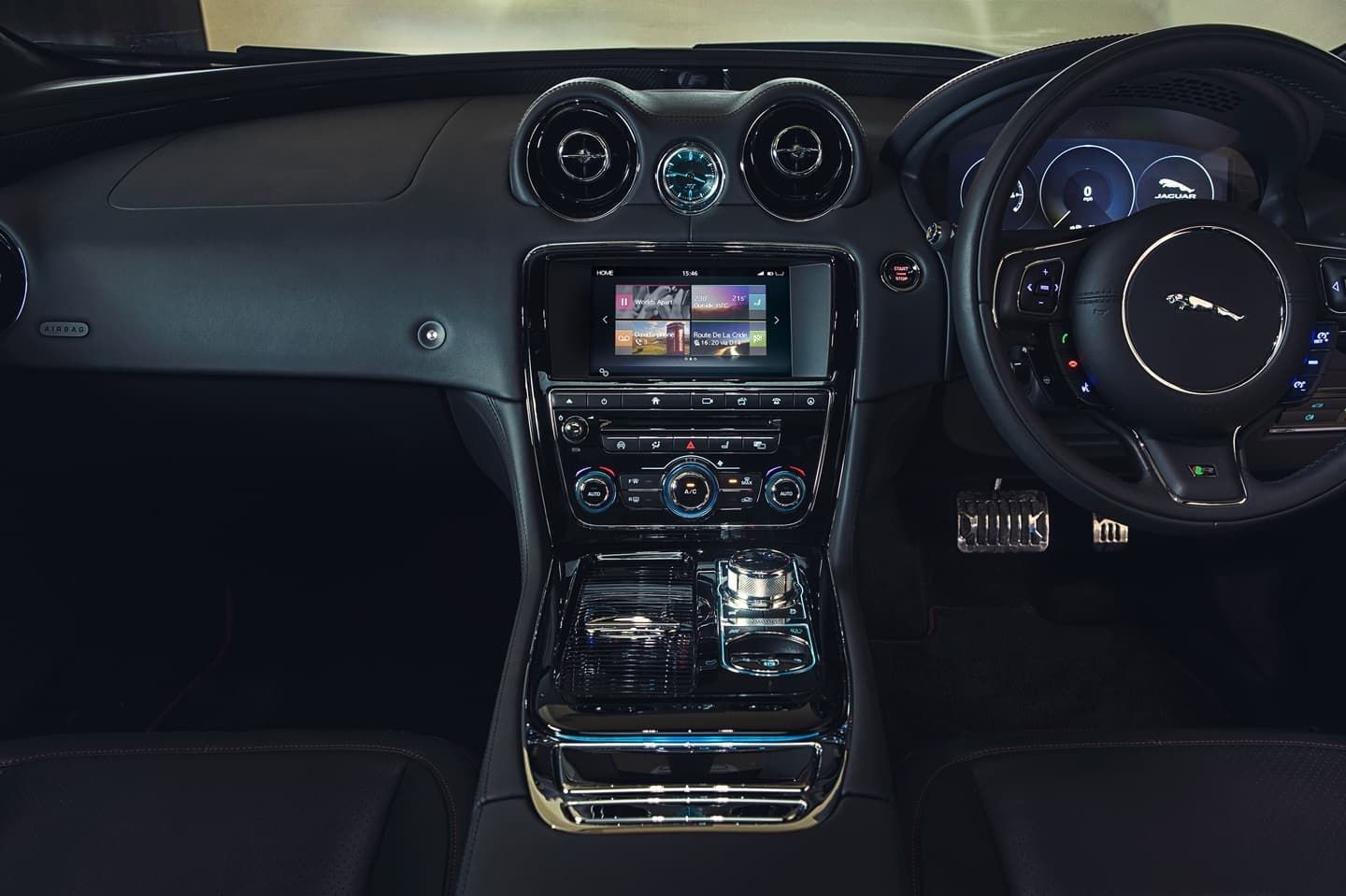 Vista de la consola central y volante del Jaguar XJ, con acabados de lujo.