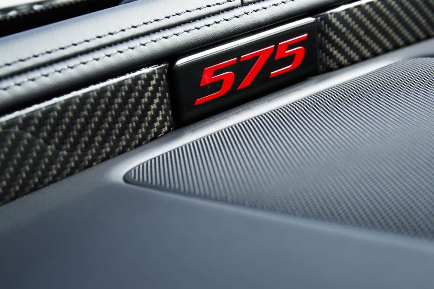 Emblema interior que indica la potencia de 575 CV.