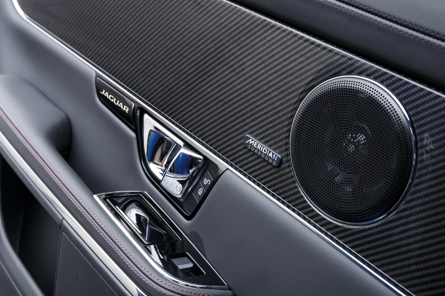 Vista del panel de puerta con acabados en fibra de carbono y sistema de sonido.