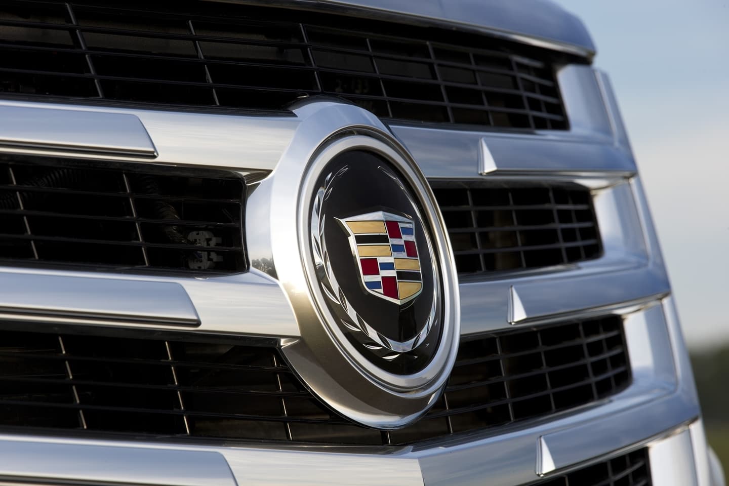 Primer plano de la icónica parrilla del Cadillac Escalade, resaltando su emblema.