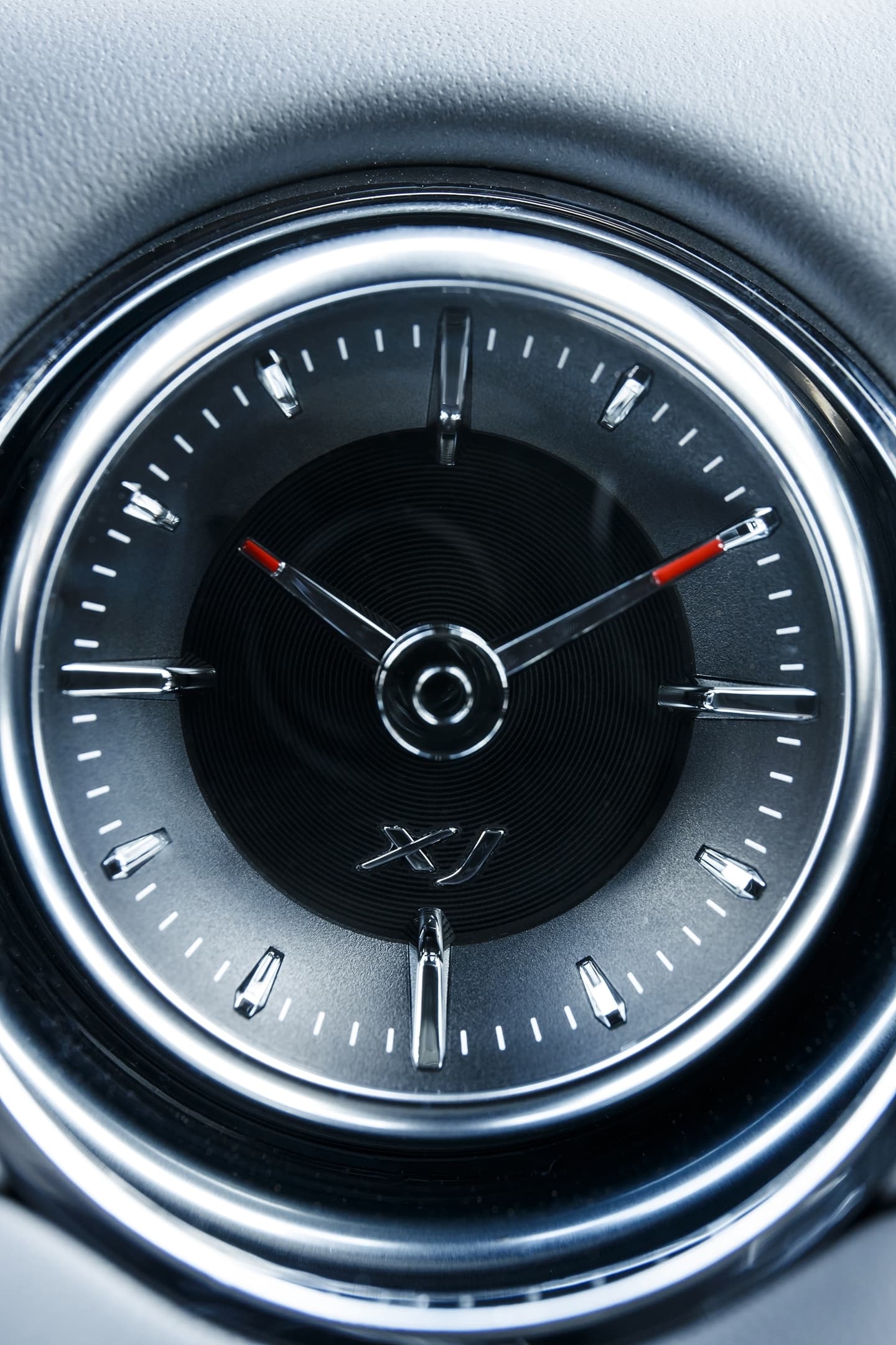 Vista cercana del reloj analógico característico en el tablero del Jaguar XJ